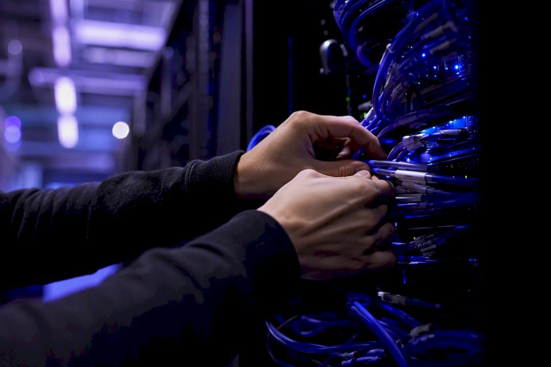 Hands connecting network cables in a data center