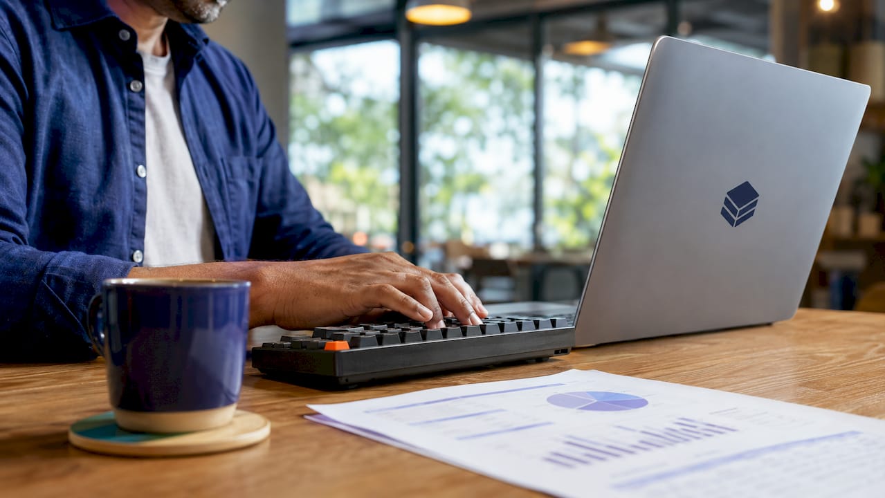 Hands typing on laptop in home office
