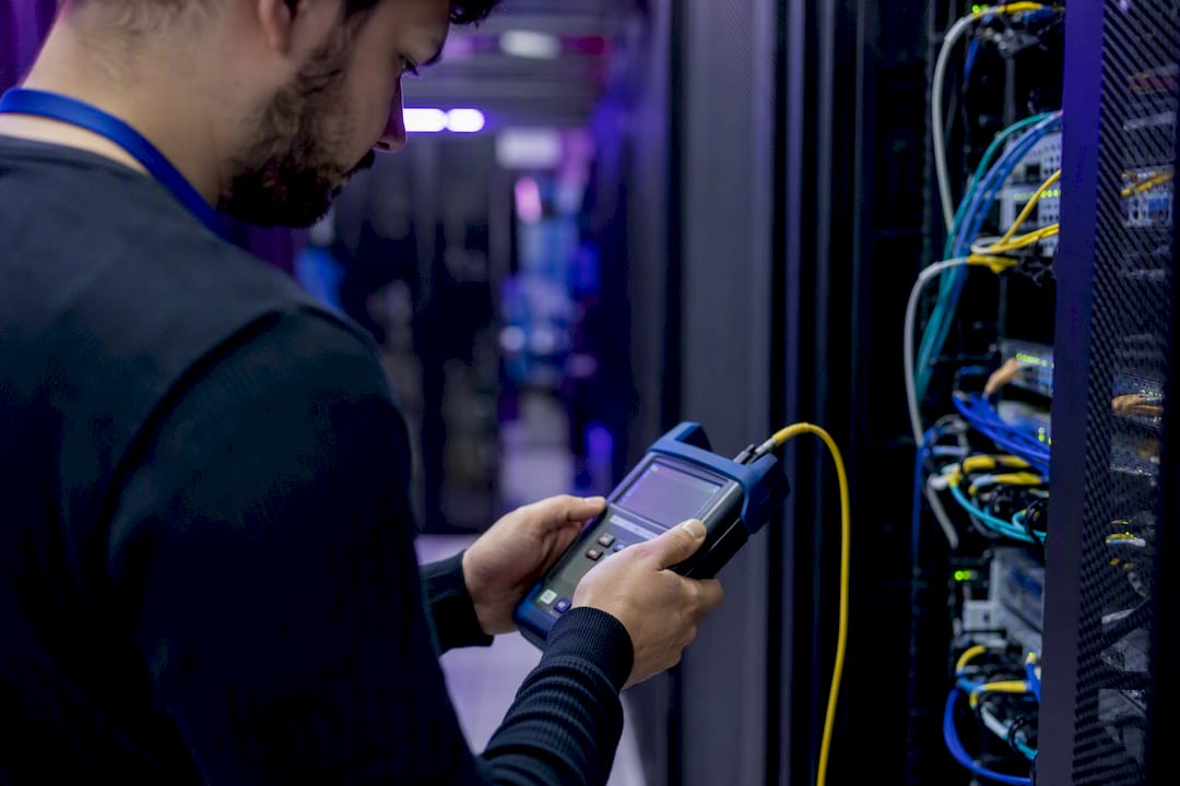 Engineer measuring network traffic with device