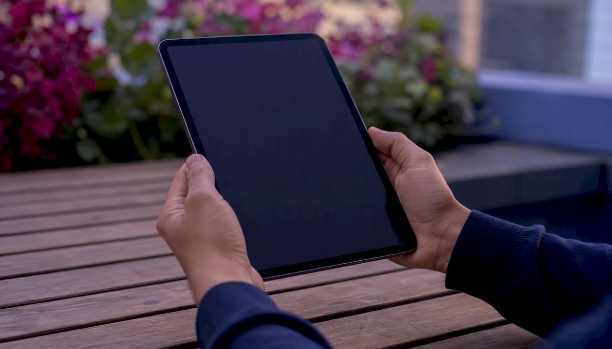 Hands holding tablet preparing dashboard insights
