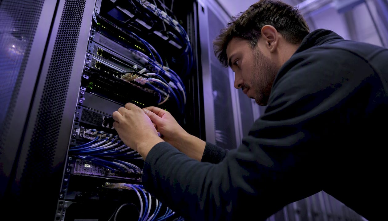 Engineer connecting cables in cloud data center