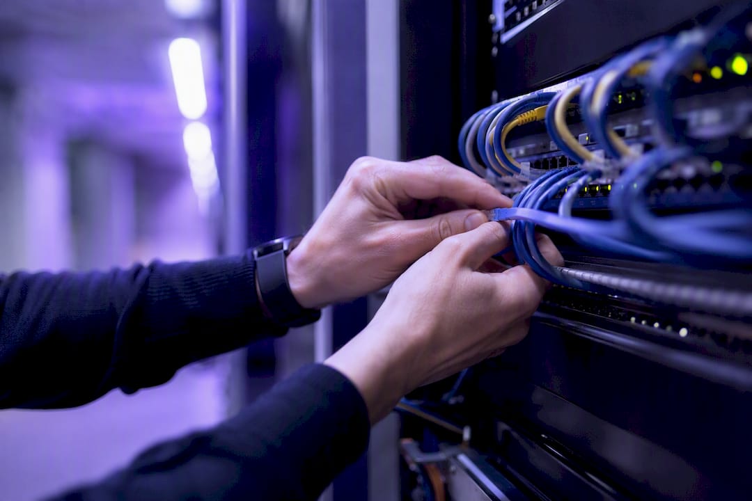 Engineer organizing network cables in data center