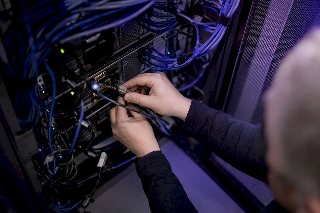 Hands connecting network cable in cloud data center