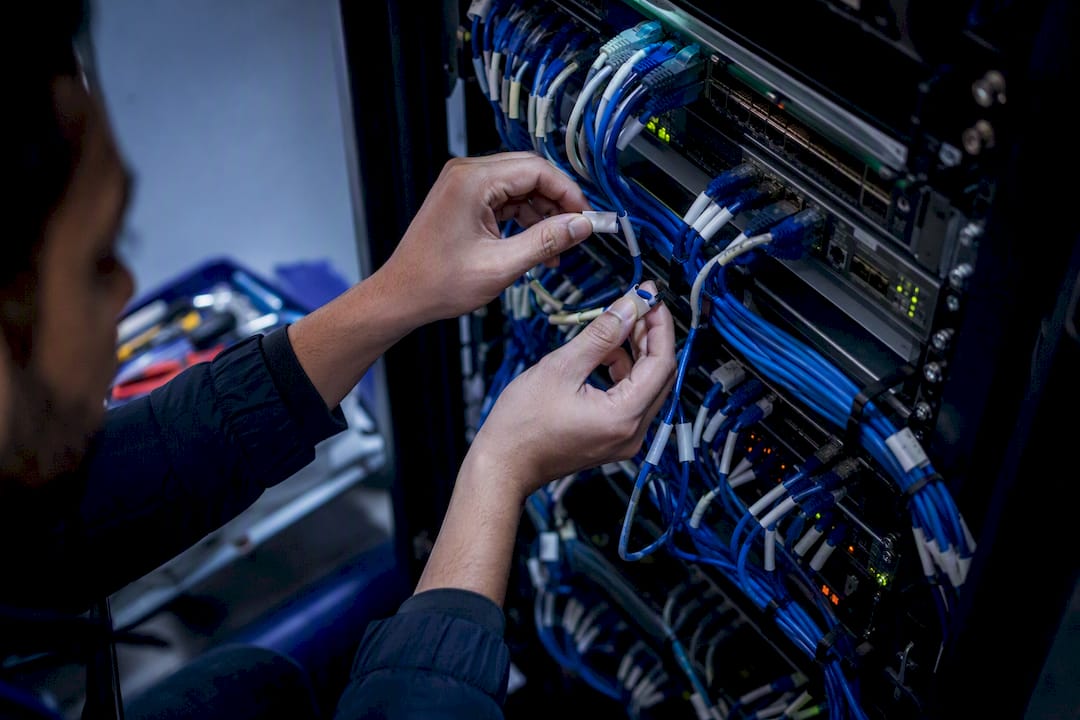 Hands wiring network cables in data center