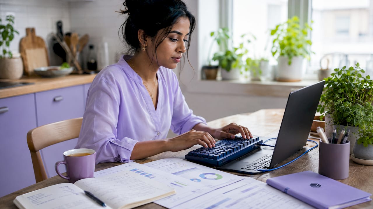 Hands typing on keyboard amid cloud cost audit documents